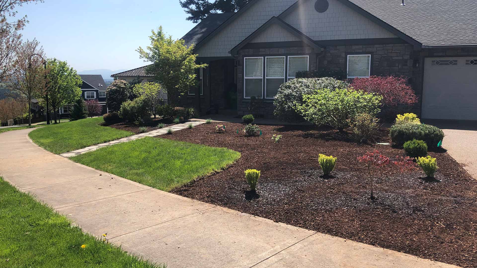 Landscape bed installation with dark mulch in Troutdale, OR.
