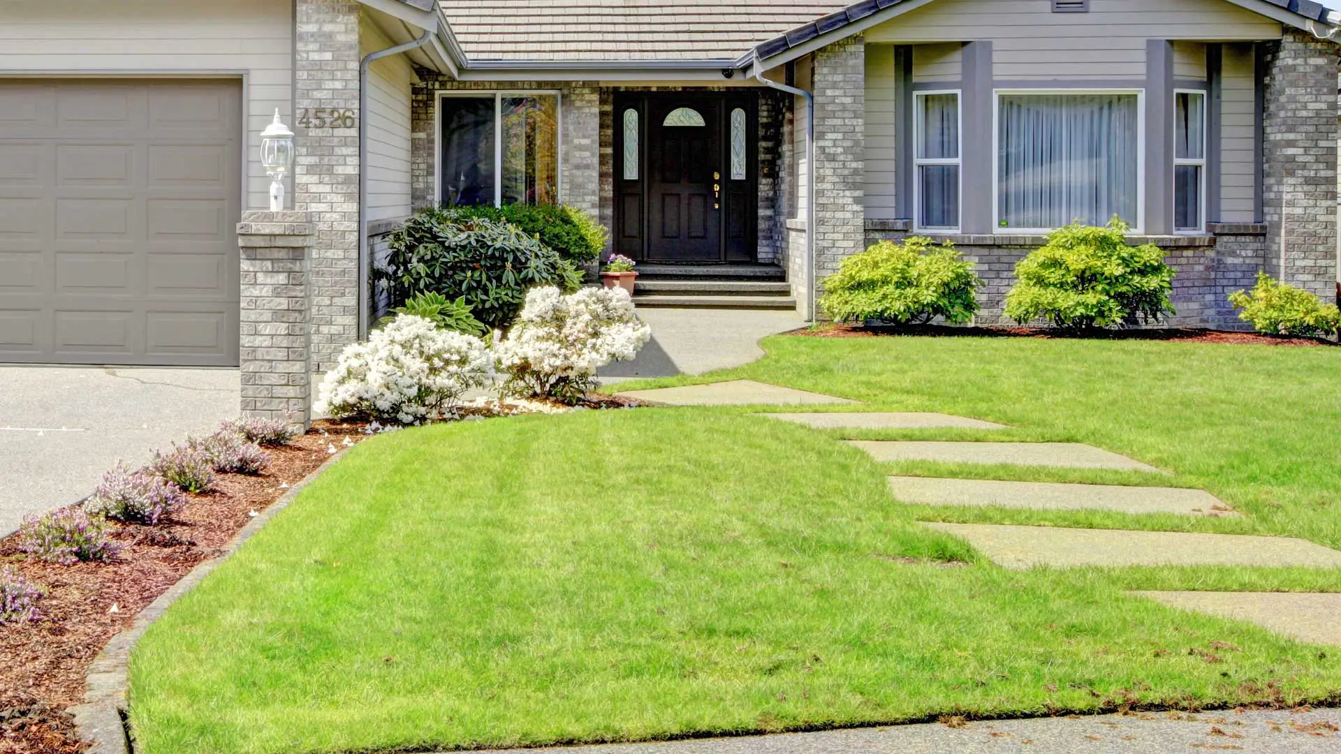 Mowed lawn and maintained landscaping by J&C Lawn Care.