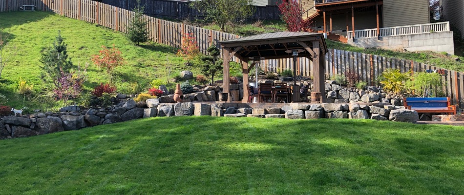 Custom patio stone retaining walls and seating area with new seeded lawn near Tigard, OR.