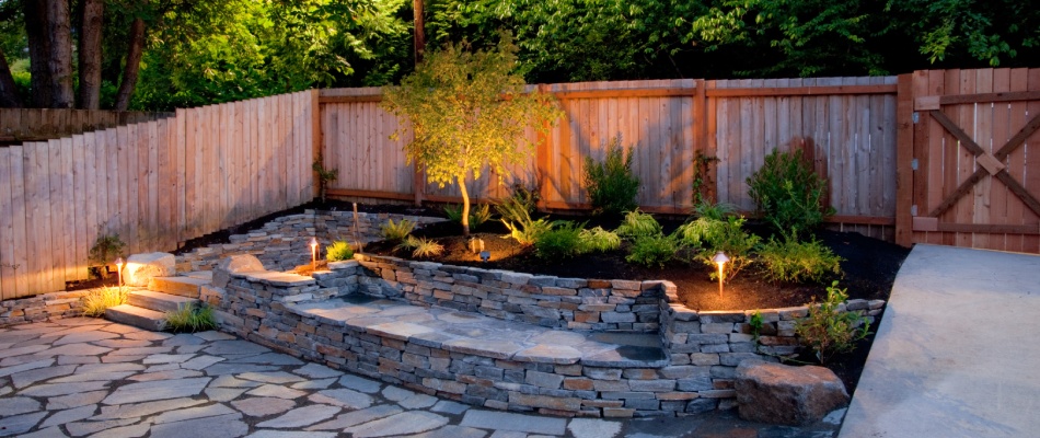 Outdoor lighting around stone paver patio and lawn bed near Happy Valley, OR.