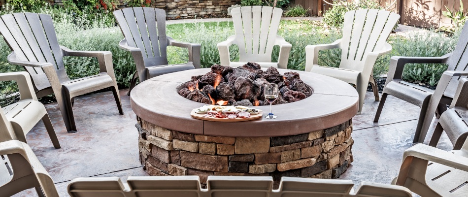 Wood burning fire pit over patio installed with seating chairs surrounding it in Beaverton, OR.